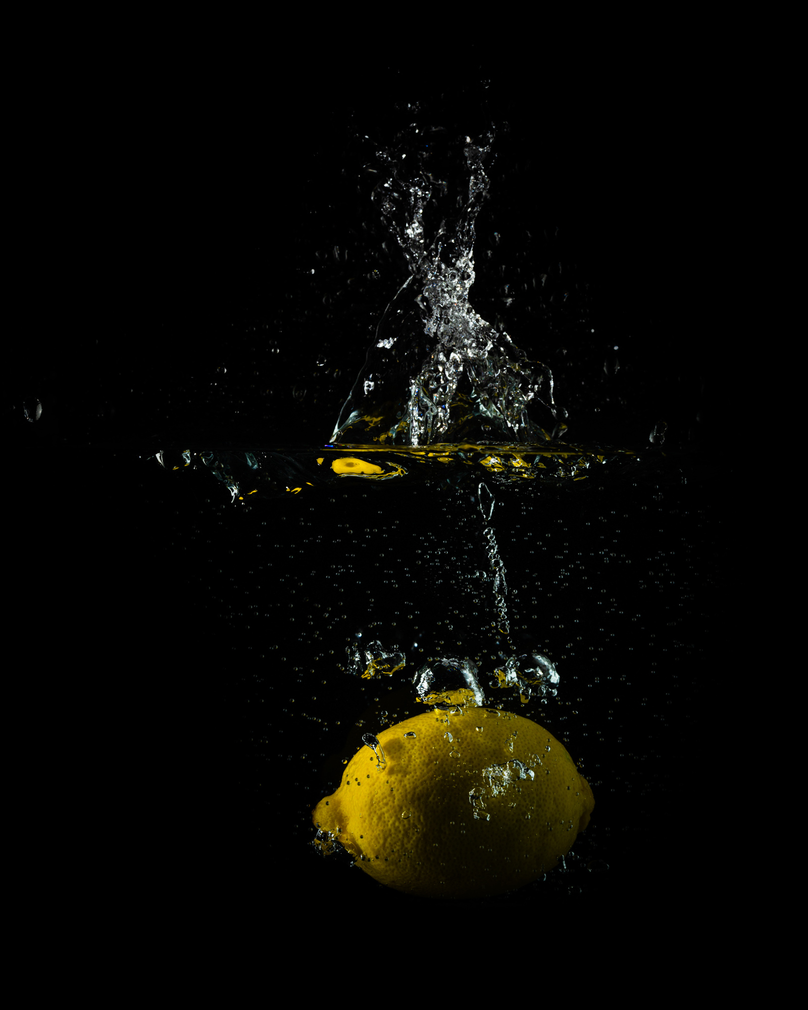 lemon splash, and lemon submerged, and air bubbles rising