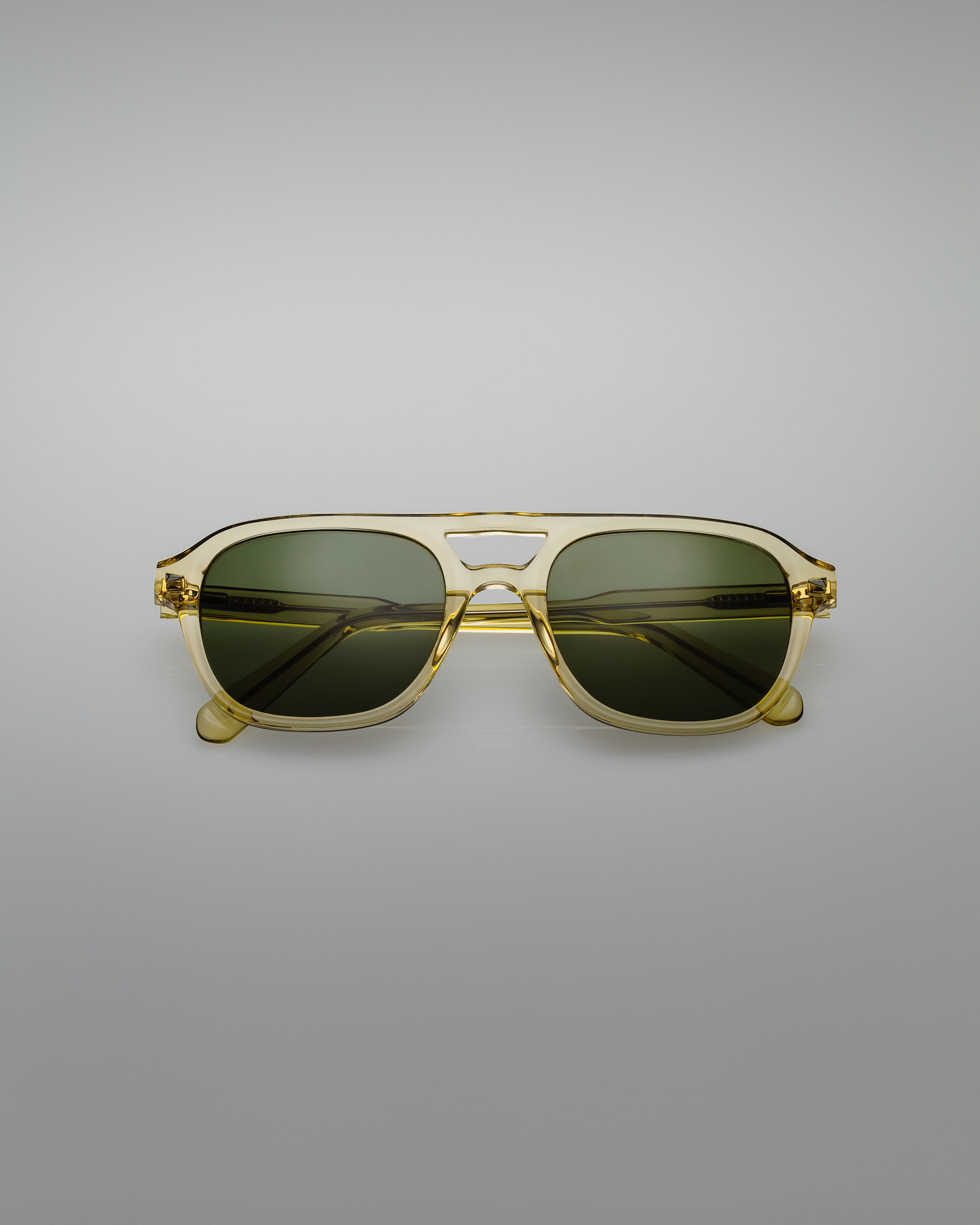Green sunglasses on a gray background.