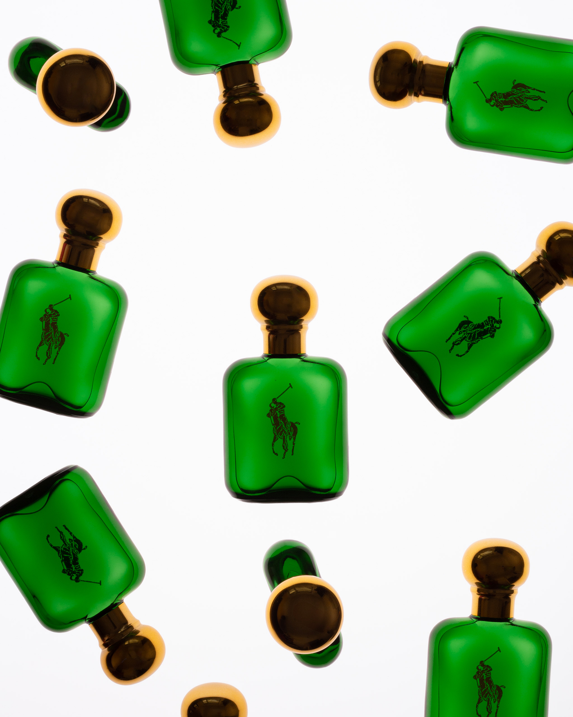 Several green rectangular perfume bottles with gold caps are arranged on a white background.