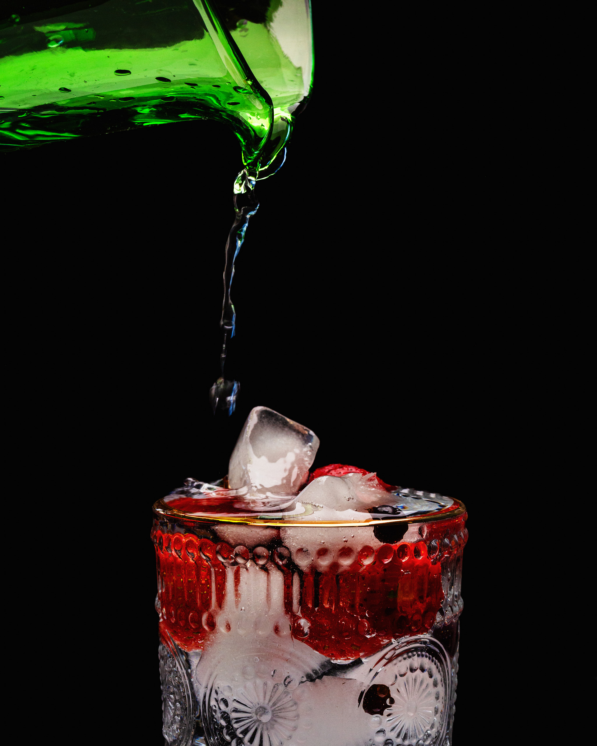 Drink with ice cubes and pouring liquid.