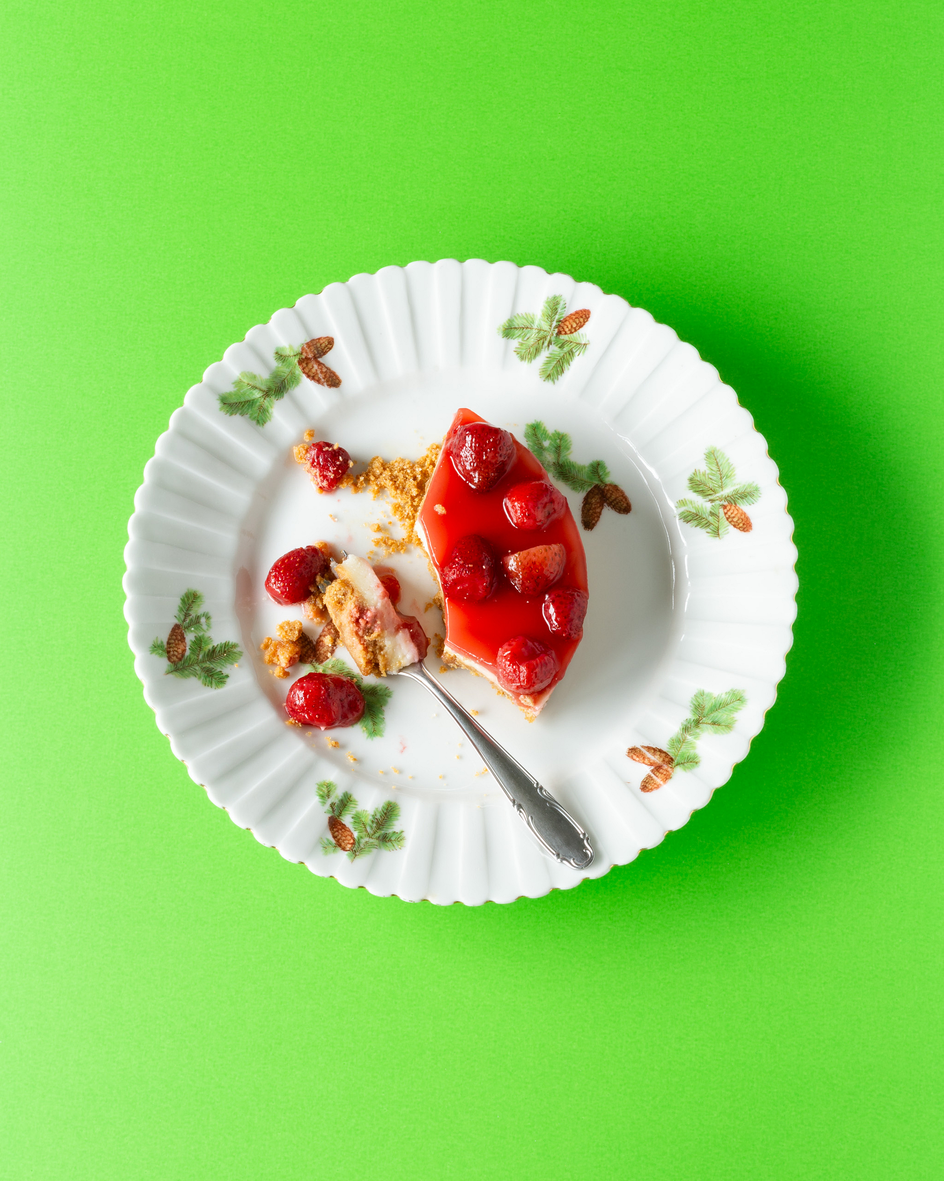 Strawberry cake on an antique plate with a green background.