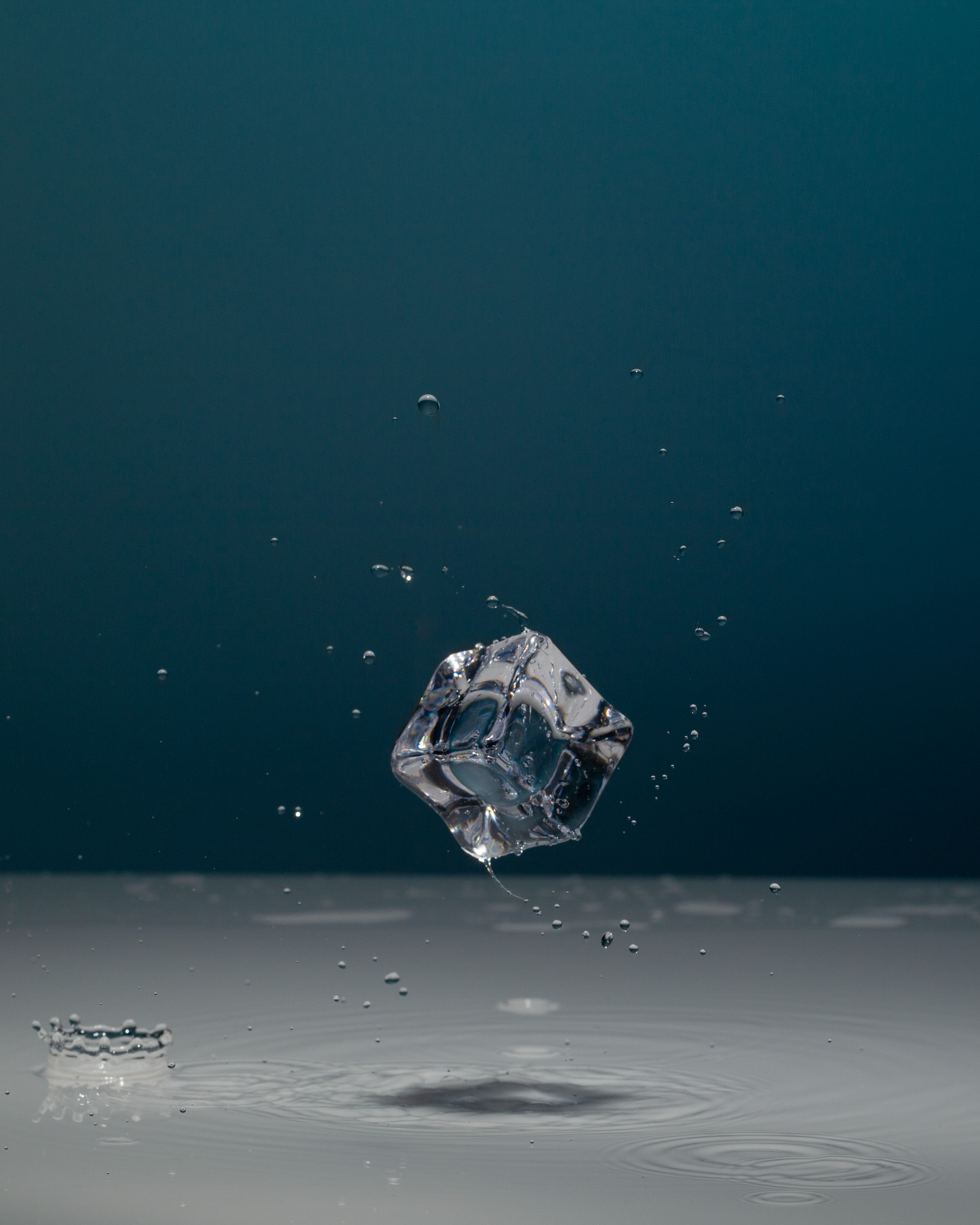 Swirling acrylic ice cube with droplets.
