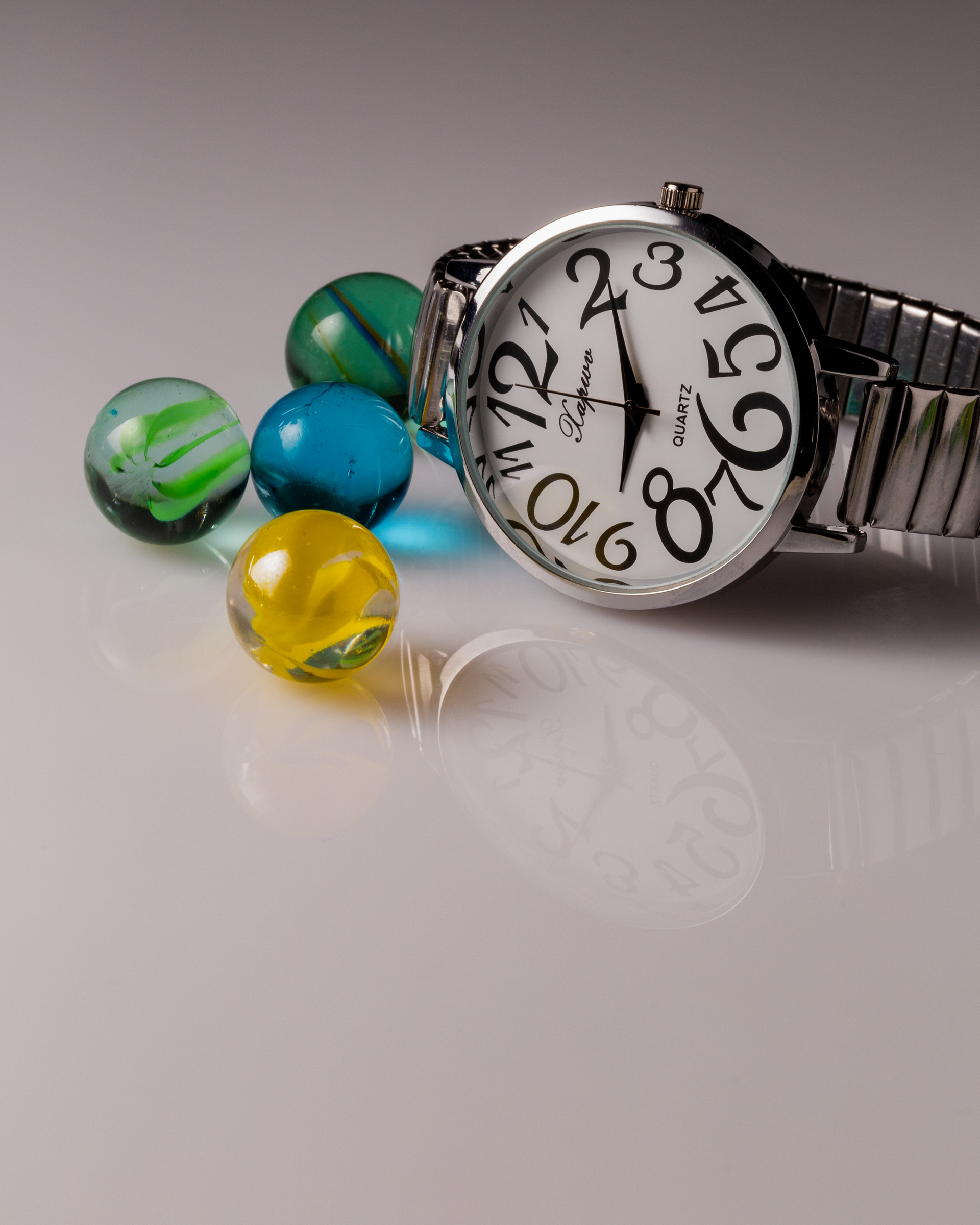 chrome watch and colourful marbles