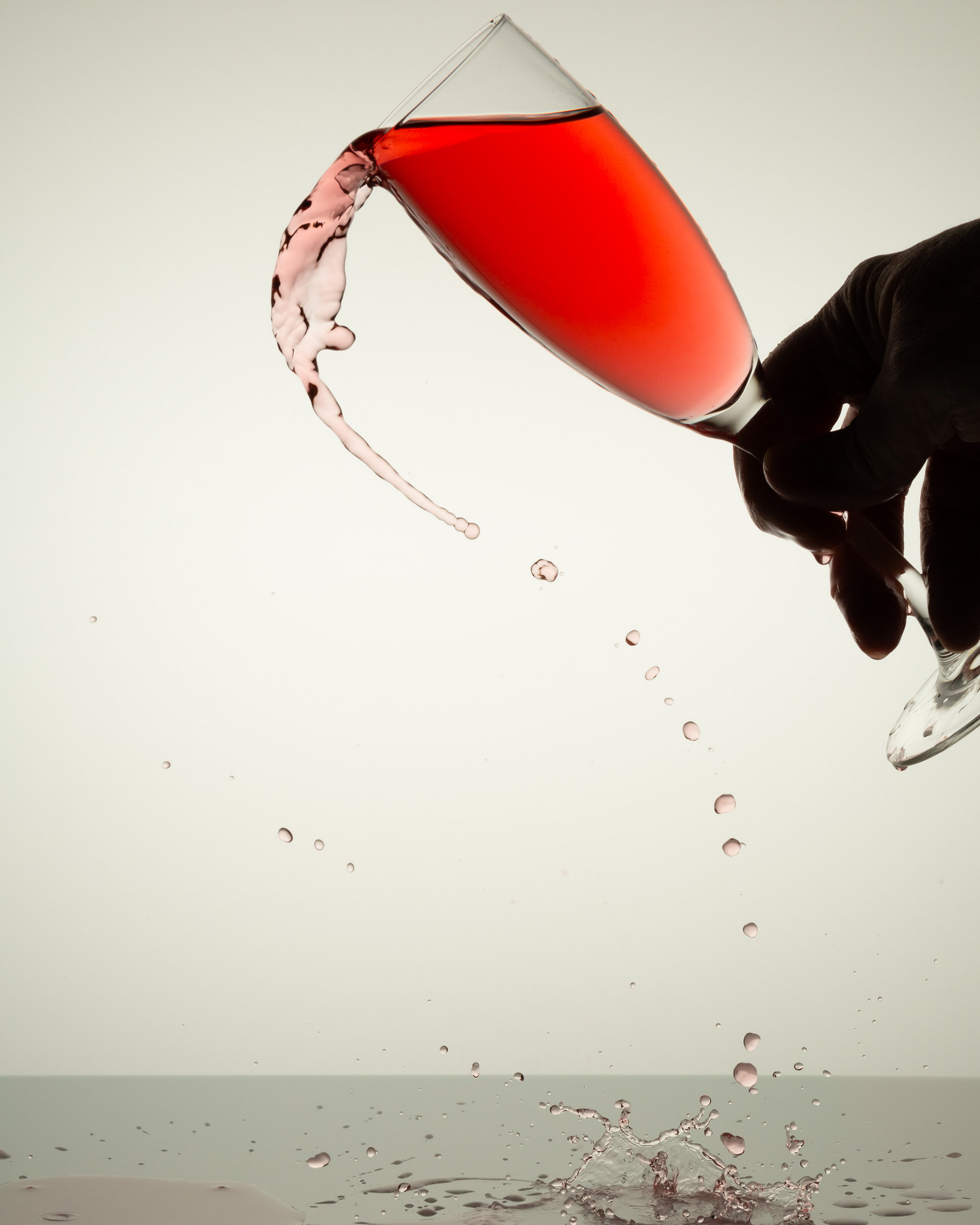 Red liquid spilling from a tipped glass.