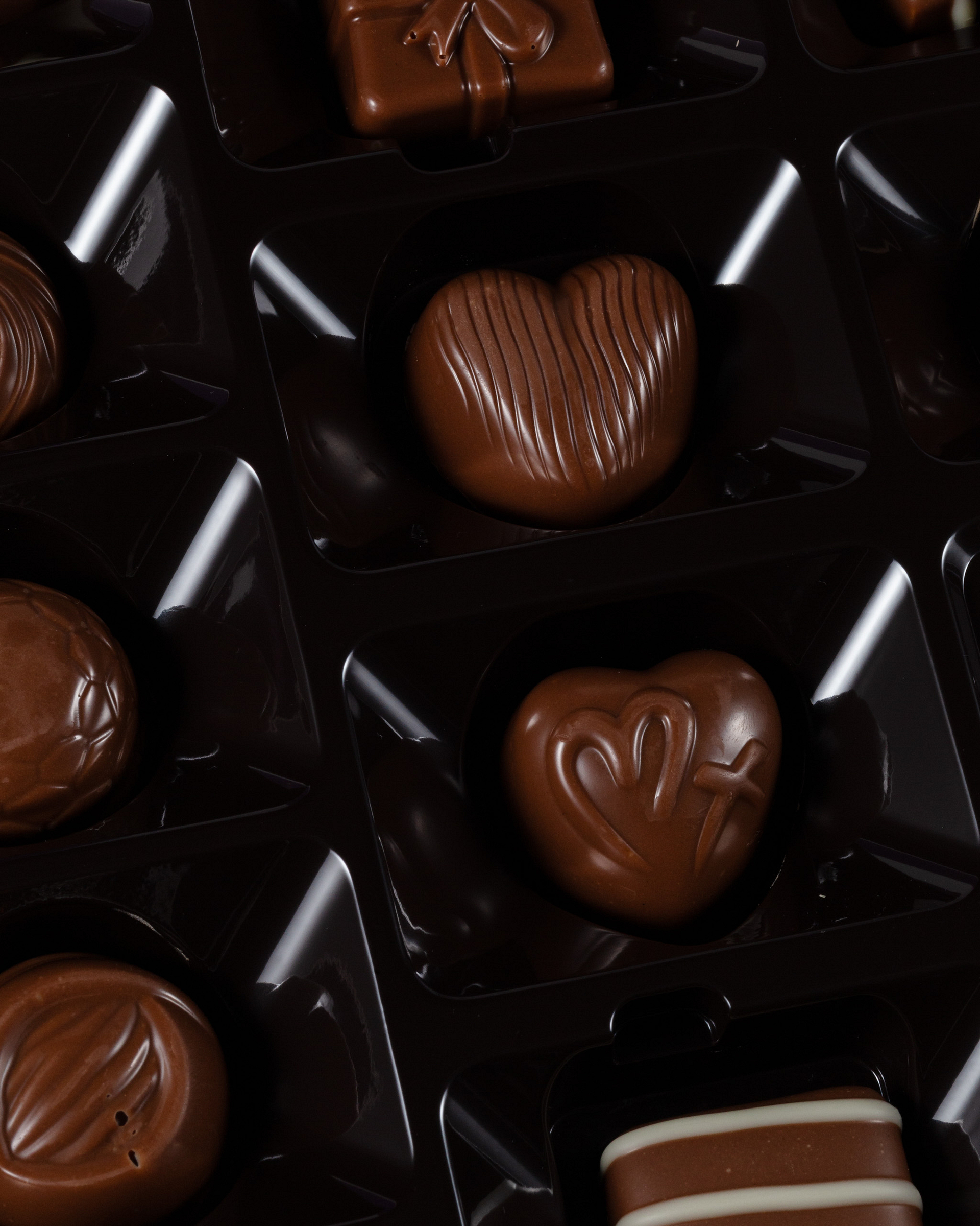 Heart-shaped chocolate pralines in a display box.