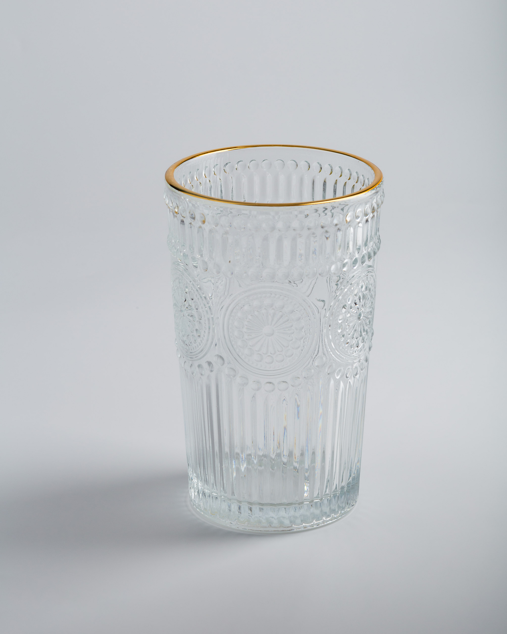 Glass with a pattern and golden edge on a light background.